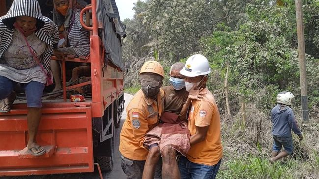  Warga atau tim evakuasi yang bergerak di kawasan terdampak — menunjukkan dampak sosial/humaniter dari erupsi.
